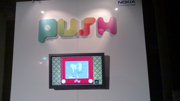An etch-a-sketch on display on a wall with Push N900 at the top